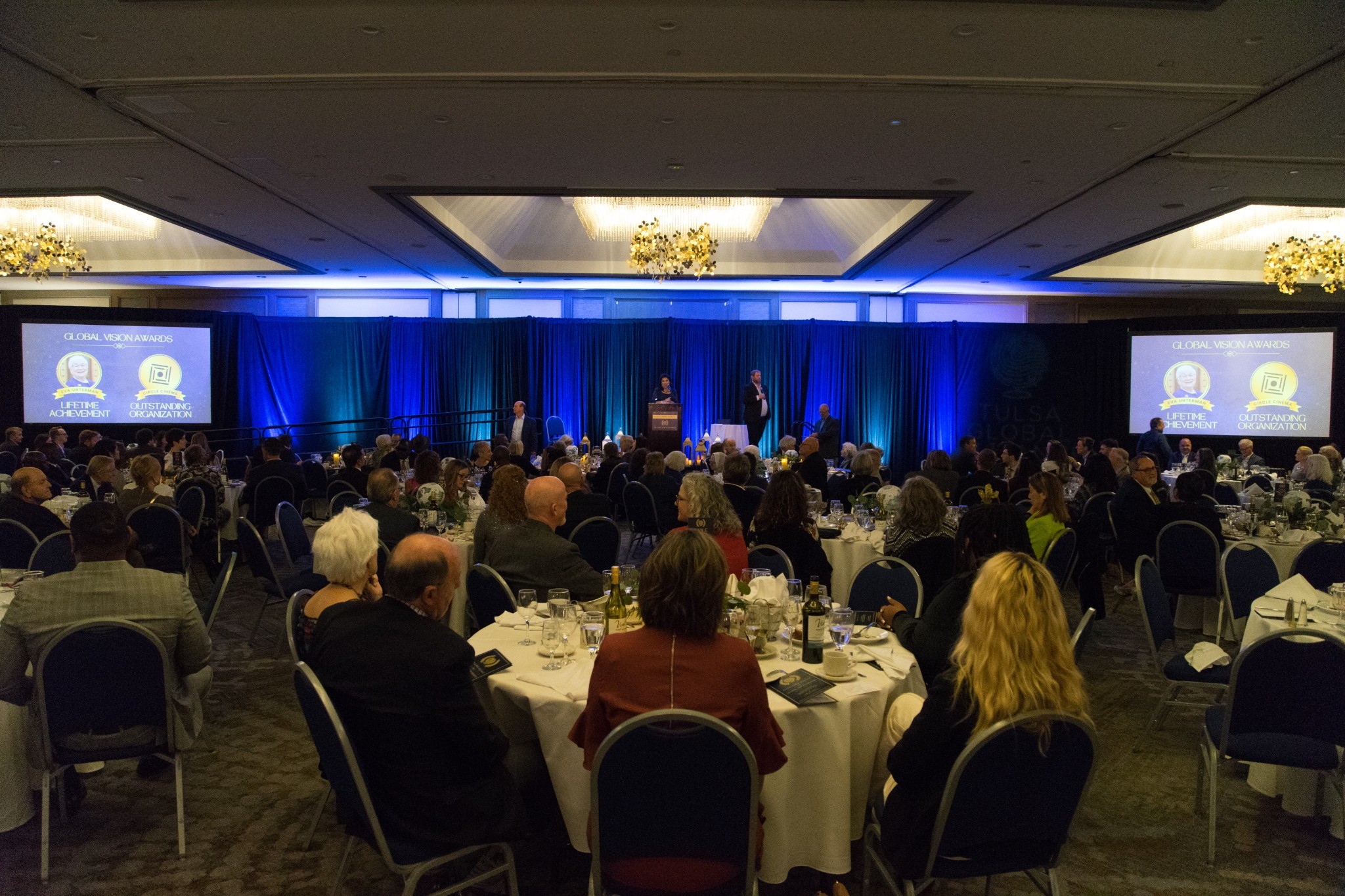 Audience gathered before a blue-lit stage at the Global Vision Awards